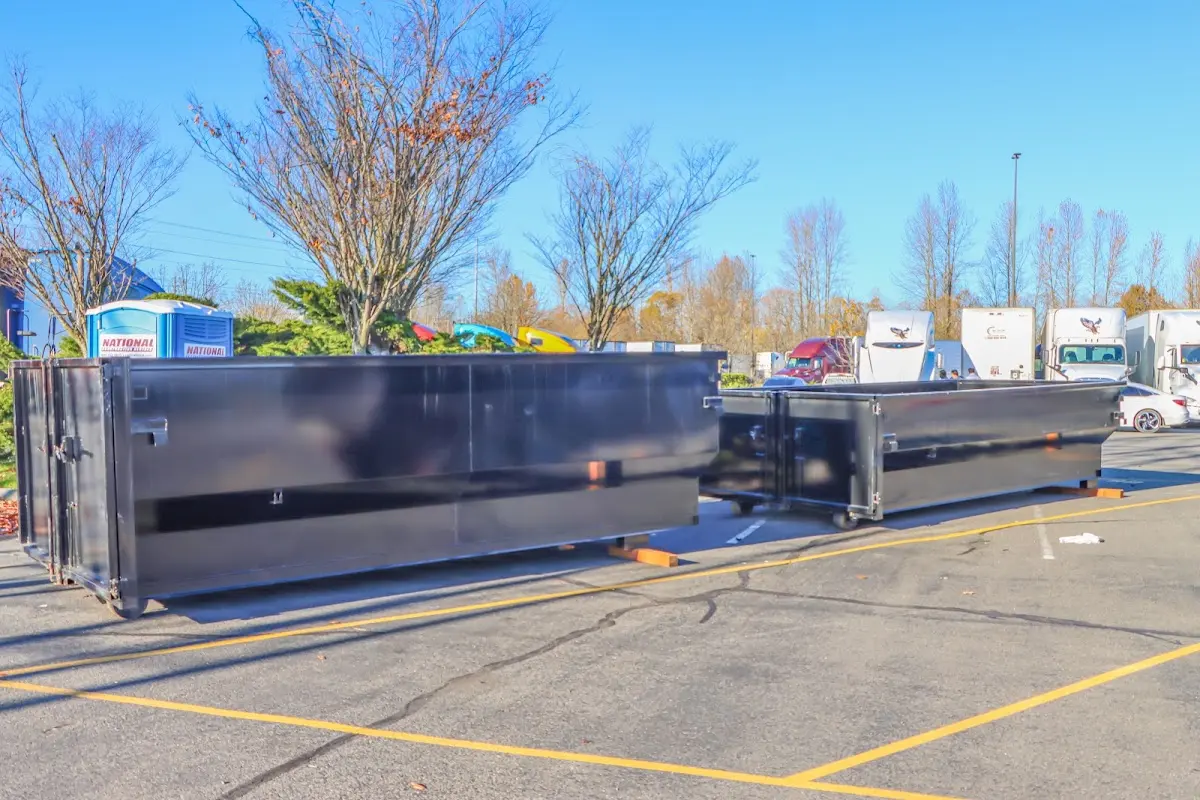 Professional dumpster rental service with roll-off container on residential driveway in Mount Rainier